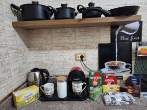 a counter with a coffee maker and cups on it at Private rooftop with jacuzzi and pyramids view in ‘Ezbet `Abd el-Ḥamîd