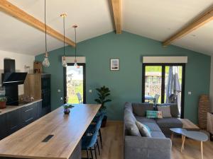 a kitchen and living room with a large wooden table at Villa le Cap in Lit-et-Mixe