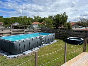 a swimming pool in a yard with a fence at Villa le Cap in Lit-et-Mixe