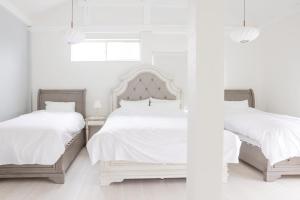 two beds in a white bedroom with white walls at 静岡 伊豆高原 ペットと泊まれるプライベートヴィラ Tous les doudouトゥレ ドゥドゥ in Ito +46 photos