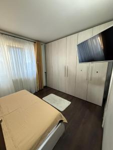 a bedroom with a bed and cabinets and a television at Apartament Craiova in Craiova