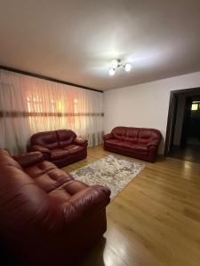 a living room with two brown leather couches and a rug at Apartament Craiova in Craiova
