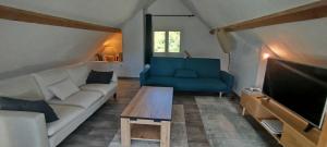 a living room with a couch and a tv at Maison pleine nature Aiguebellette et Bourget in Loisieux