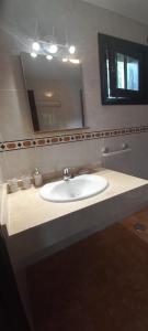 a bathroom with a white sink and a mirror at Aretina's Lanzarote Retreat in Costa Teguise