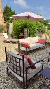 a patio with two chairs and an umbrella at La Corte Nascosta Volpedo in Volpedo
