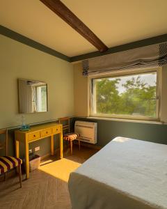 une chambre avec un lit, une fenêtre et un bureau dans l'établissement La Corte Nascosta Volpedo, à Volpedo