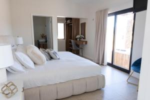 a bedroom with a large bed with white sheets and pillows at Villas Baja Toscana de Rancho Olivares in Ensenada