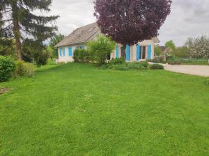 a house with a yard with green grass at Le jardin d'Annie Chambres D'hôtes in Jaucourt