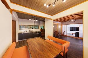 a kitchen and dining room with a wooden table and chairs at 樹-Itsuki- "岩風呂付 rockbath" in Hakone