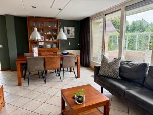 una sala de estar con un sofá y una mesa en Previnaireweg 24, en Callantsoog