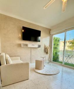 a living room with a flat screen tv on the wall at Entre Ciel&Mer in Palavas-les-Flots