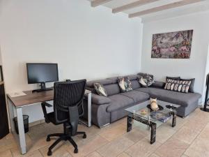 Una sala de estar con un sofá y un escritorio. en Stilvoll am Wald wohnen 115 qm Office citynah, en Stockstadt am Main