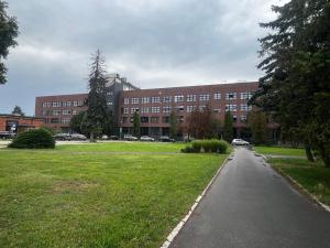 a large brick building with cars parked in front of it at Sweet Apartment Hydral in Wrocław