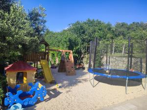 a playground with a slide and a swing set at Apartments Luka in Rab