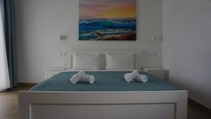 ein weißes Bett mit zwei Kissen darüber in der Unterkunft Angelina Hotel in Ormos Panagias