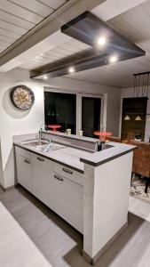 cocina grande con fregadero y reloj en la pared en Ferienhaus Meer & Mehr, en Wilhelmshaven