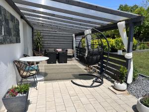 a patio with a table and chairs under a pergola at La Mia Casa Apartman Gyenesdiás in Gyenesdiás