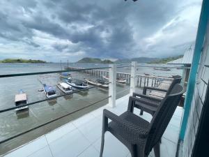 a chair on a balcony with a view of the water at Rusde's Komodo Homestay in Pulau Komodo +50 photos