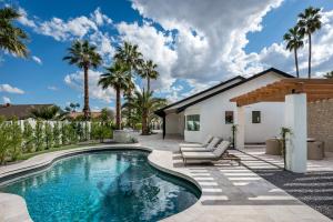 a swimming pool in the backyard of a house with palm trees at The MYAH by Porter NEWLY REMODELED Enjoy the Pool Firepit Luxury in Phoenix
