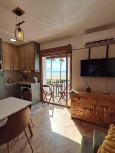 a living room with a television and a kitchen with a table at Apartman CA34 in Villajoyosa