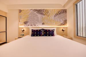 a bedroom with a large white bed and a window at Keys Lite by Lemon Tree Hotels, Banswara in Bānswāra +49 photos