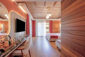 a hotel room with a bed and a television at Cirali Hera Hotel in Cıralı