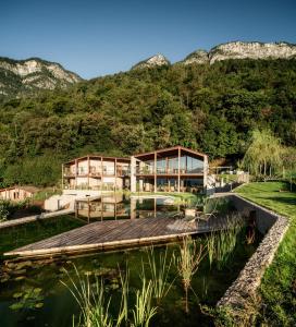 a house in the mountains with a pond at Nikolausberg - Hof im Garten in Caldaro