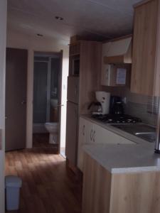 a kitchen with wooden cabinets and a sink and a toilet at Camping Ter Hoeve in Bredene