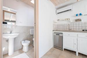 a white bathroom with a sink and a toilet at La Depandance di Villa d'oro in La Maddalena