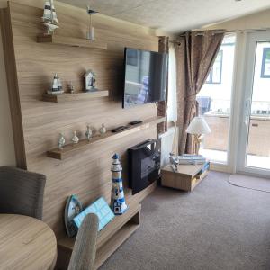 a living room with a television on a wall at 125 Maple Lake Southview Caravan Park in Winthorpe +10 photos