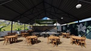a patio with tables and chairs and a stage at AURA Lounge in Udawalawe