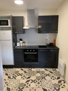 a kitchen with a black and white tile floor at Le compromis entre La Défense et Argenteuil in Argenteuil +3 photos