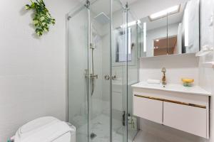 een badkamer met douche, toilet en wastafel bij Trendy 4BR Petersham Stay Steps from Top Cafés in Sydney +10 foto's