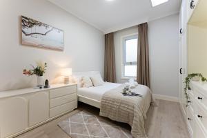 een witte slaapkamer met een bed en een raam bij Trendy 4BR Petersham Stay Steps from Top Cafés in Sydney