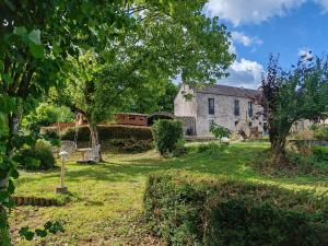 a yard with an old house and a building at L'Etape in Pont-d'Ouilly