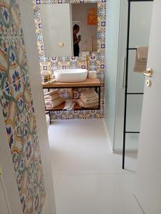 un baño con lavabo y espejo en Dimora di Ripalta suite e rooms, en Brindisi