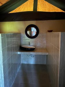 une salle de bain avec un lavabo et un miroir dans l'établissement Eco Mara Tented Camp, à Ololaimutiek