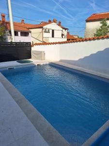 una piscina con acqua blu davanti a una casa di Blue Pool House Rakalj a Rakalj