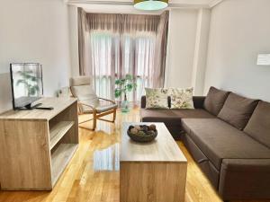 a living room with a couch and a table at Apartamentos El Caxigu in Arenas de Cabrales