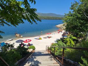 una spiaggia con ombrelloni e persone sulla sabbia e sull'acqua di Blue Pool House Rakalj a Rakalj