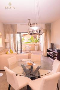 un soggiorno con tavolo in vetro e sedie bianche di Appartement de Luxe au Domaine des Alizées Club & Spa, Grand Baie a Grand Baie Altre 8 foto