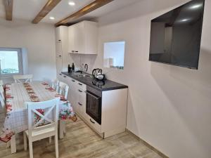 una cucina e una sala da pranzo con tavolo e piano cottura di Blue Pool House Rakalj a Rakalj