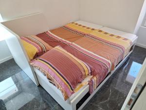 un letto bianco con coperte colorate sopra di Blue Pool House Rakalj a Rakalj Altre 6 foto