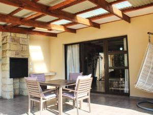 un tavolo da pranzo con sedie e una TV di Muirfield Cottages a Clarens