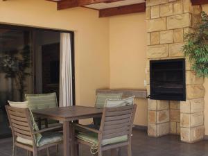 un tavolo e sedie in legno su un patio con camino di Muirfield Cottages a Clarens