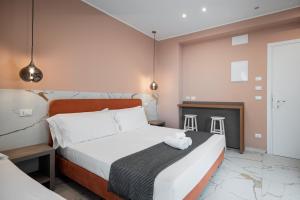 a bedroom with a bed and two stools at Hotel Cola Frontemare in Bellaria-Igea Marina