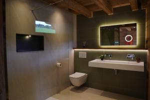 a bathroom with a toilet and a sink and a tv at CHALET TEKA LES GETS - Appartement Duplex in Les Gets +46 photos