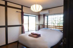 une chambre avec un grand lit blanc et une fenêtre dans l'établissement Cottage Atami-Momoyama-Town コテージ熱海桃山町, à Atami
