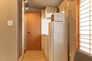 a refrigerator with a microwave on top of it in a room at Asagaya House by Tranova in Tokyo