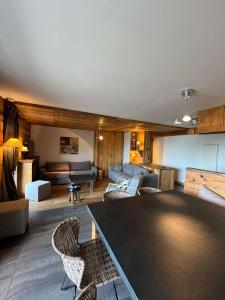 LandryにあるSpacieux 5 pièces sur Peisey-Vallandry - ski aux piedsのソファとテーブルのあるリビングルーム